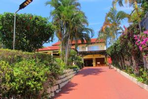 a person walking down a red path in front of a building at Keke Place in Vila Praia Do Bilene