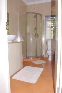 a bathroom with a shower and a toilet and a sink at Keke Place in Vila Praia Do Bilene +46 photos