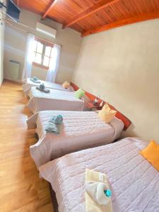 a group of four beds in a room at Apart Hotel Rústicos Valentina in Dolores