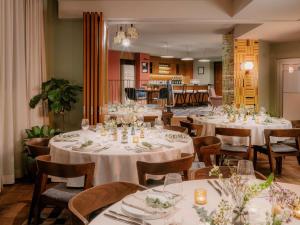 een eetkamer met witte tafels en stoelen bij The Hoxton Vienna in Wenen