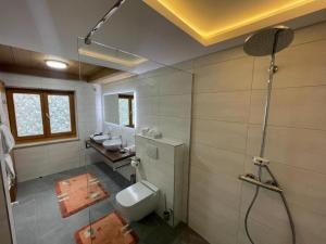 een badkamer met een toilet en 2 wastafels. bij Hotel Sonnleiten in Reit im Winkl +63 foto's