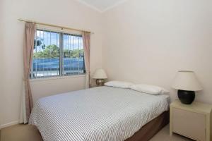 une chambre blanche avec un lit et une fenêtre dans l'établissement Dream Weaver, à Bawley Point 9 autres photos