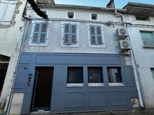 a building with a blue door and windows at Le Cocon Authentique in Mont-de-Marsan