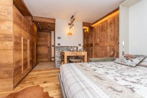 une chambre avec un lit et un mur en bois dans l'établissement Maison Meynet Mountain Charm, à Breuil-Cervinia