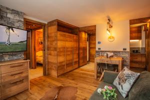 un salon avec une télévision et un canapé dans l'établissement Maison Meynet Mountain Charm, à Breuil-Cervinia