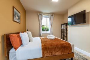 a bedroom with a large bed and a television at Yarrow cottage in Broadmeadows