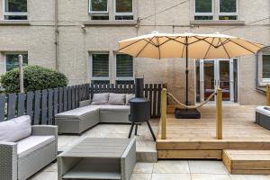 a patio with an umbrella and a couch and a table at Yarrow cottage in Broadmeadows +22 photos