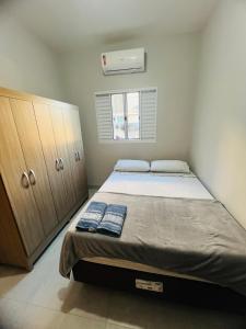 ein kleines Schlafzimmer mit einem Bett und einem Fenster in der Unterkunft Residencial Yama - Hospedagens in Paranavaí