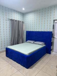 un letto blu in una stanza con carta da parati blu di Hôtel Africa Pas Chers a Conakry