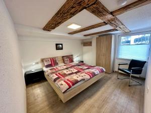 een slaapkamer met een bed en een stoel erin bij Schwarzwald Residenz in Bad Dürrheim