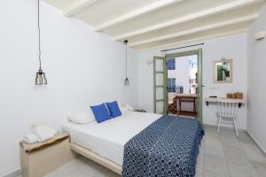 a white bedroom with a bed and a table at Nastasia Village in Naxos Chora