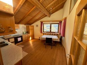 a kitchen with a table in the middle of a room at Dolomiten View - South Tyrol in Villandro