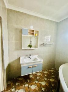 a bathroom with a sink and a tub at Asamez Apartments in Lilongwe