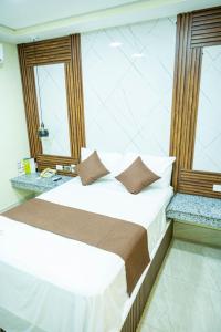 a bedroom with a bed and two windows at Hotel Monterio in Azua