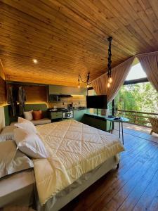 a bedroom with a large bed and a kitchen at Taboo Refúgio in Nova Petrópolis
