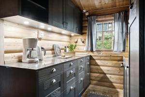 een keuken met houten wanden en een aanrecht met een koffiezetapparaat bij Cabin With Panoramic Views Over Trysil in Trysil
