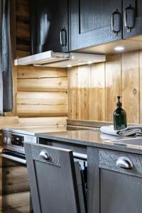 een keuken met houten kasten en een fles wijn op het aanrecht bij Cabin With Panoramic Views Over Trysil in Trysil