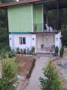 een groen en wit huis met een balkon bij Patcharin lanta gardan house in Ko Lanta Yai