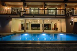 a large swimming pool in a building with a house at Lankahuts in Negombo