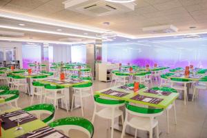 een eetkamer met groene tafels en witte stoelen bij Hotel Servigroup Romana in Alcossebre