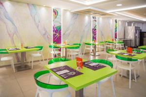 een eetkamer met groene tafels en groene stoelen bij Hotel Servigroup Romana in Alcossebre +44 foto's