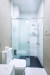 a bathroom with a glass shower with a toilet at Lankahuts in Negombo +23 photos