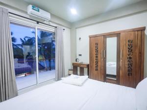 a bedroom with a bed and a large window at Lankahuts in Negombo