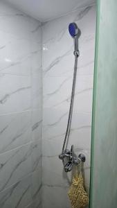a shower with a blue shower head in a bathroom at Tariq Camp Wadi Rum in Wadi Rum