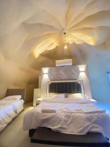 a bedroom with a large bed with a large ceiling at Tariq Camp Wadi Rum in Wadi Rum