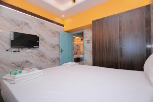 una camera con letto bianco e TV a parete di HOTEL CYRIL a Kanyakumari