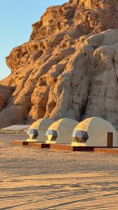 a group of domes in front of a mountain at Tariq Camp Wadi Rum in Wadi Rum