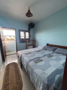 een slaapkamer met een bed met een blauw dekbed bij Pousada Vila Caburé in Luis Correia
