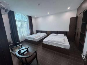 a hotel room with two beds and a chair at Phú Thọ Hotel in Chú Mật +5 photos