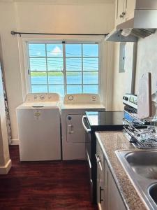 una cucina con lavandino e lavatrice/asciugatrice di Koror ocean view a Koror