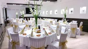 a dining room with white tables and white chairs at Hotel Vinarsky Dom in Pezinok