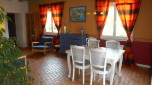 uma sala de jantar com mesa e cadeiras em La Poiriere em Chemellier