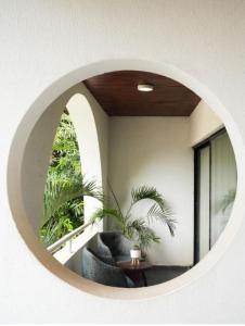 een woonkamer met een ronde spiegel aan de muur bij Bito luxury - Wuse ll in Abuja