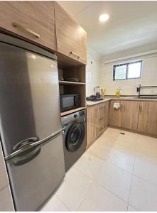 een keuken met een roestvrijstalen koelkast en een vaatwasser bij Bito luxury - Wuse ll in Abuja +10 foto's