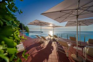 a group of chairs and umbrellas next to a pool at HVD Boutique Hotel Oasis - Private Beach & Free Parking in Golden Sands