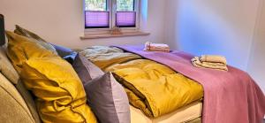 a bed with colorful blankets on it in a room at Haus Theda in Fockbek