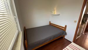 a small bed in a room next to a window at Apartman a tengernél in Vir