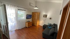 a living room with a couch and a television at Apartman a tengernél in Vir