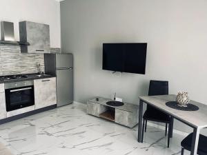 a kitchen with a table and a tv on the wall at GioNi HOUSE in Collegno +10 photos