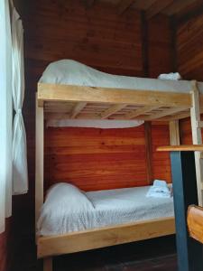 Ce lit se trouve dans un dortoir doté de 2 lits superposés et de murs en bois. dans l'établissement El Estribo, à Lago Puelo
