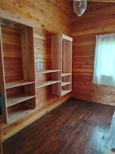 Cette chambre dispose de murs et d'étagères en bois ainsi que d'une fenêtre. dans l'établissement El Estribo, à Lago Puelo