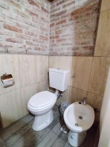 une salle de bain avec des toilettes blanches et un lavabo dans l'établissement El Estribo, à Lago Puelo