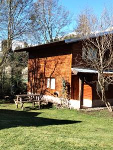 une cabane en rondins avec un banc devant elle dans l'établissement El Estribo, à Lago Puelo