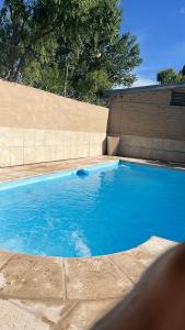 een groot blauw zwembad naast een bakstenen muur bij Complejo Cabañas del Cristo in San Rafael