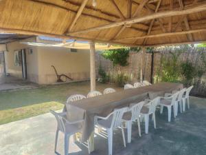 een lange tafel en stoelen onder een houten dak bij Complejo Cabañas del Cristo in San Rafael