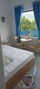 a bedroom with a bed and a table and a window at Homestay xóm nhỏ in Ninh Hải